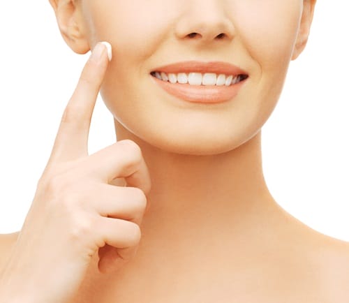 beautiful woman applying moisturizing cream