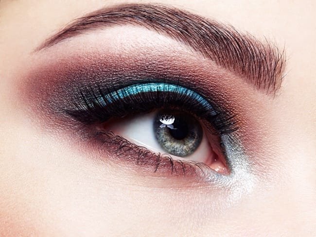 Beautiful woman face. Perfect makeup. Beauty fashion. Eyelashes. Lips. Cosmetic Eyeshadow. Make-up detail. Eyeliner