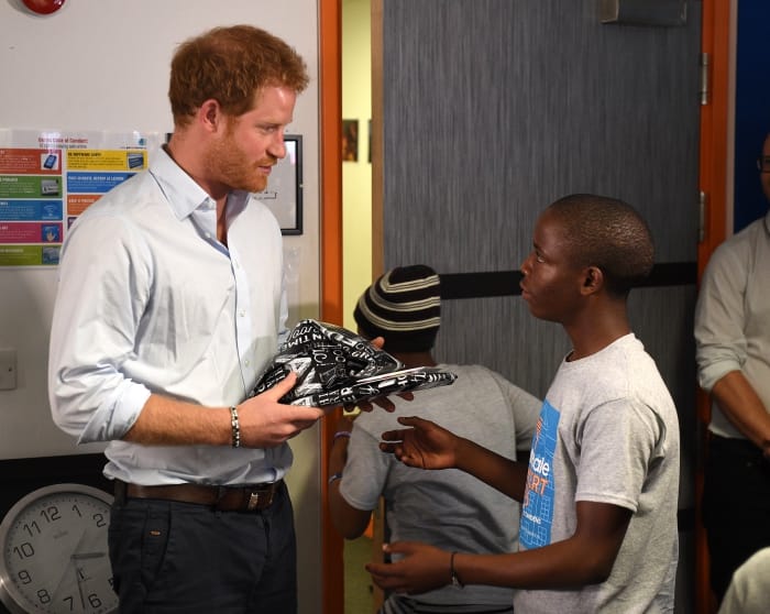 Prince Harry (left) is presented with a gift by Relebohile 'Mutsu' Potsane after watching members of the Basotho Youth Choir during their rehearsals at the Brit School ahead of a performance at the Sentebale Concert.